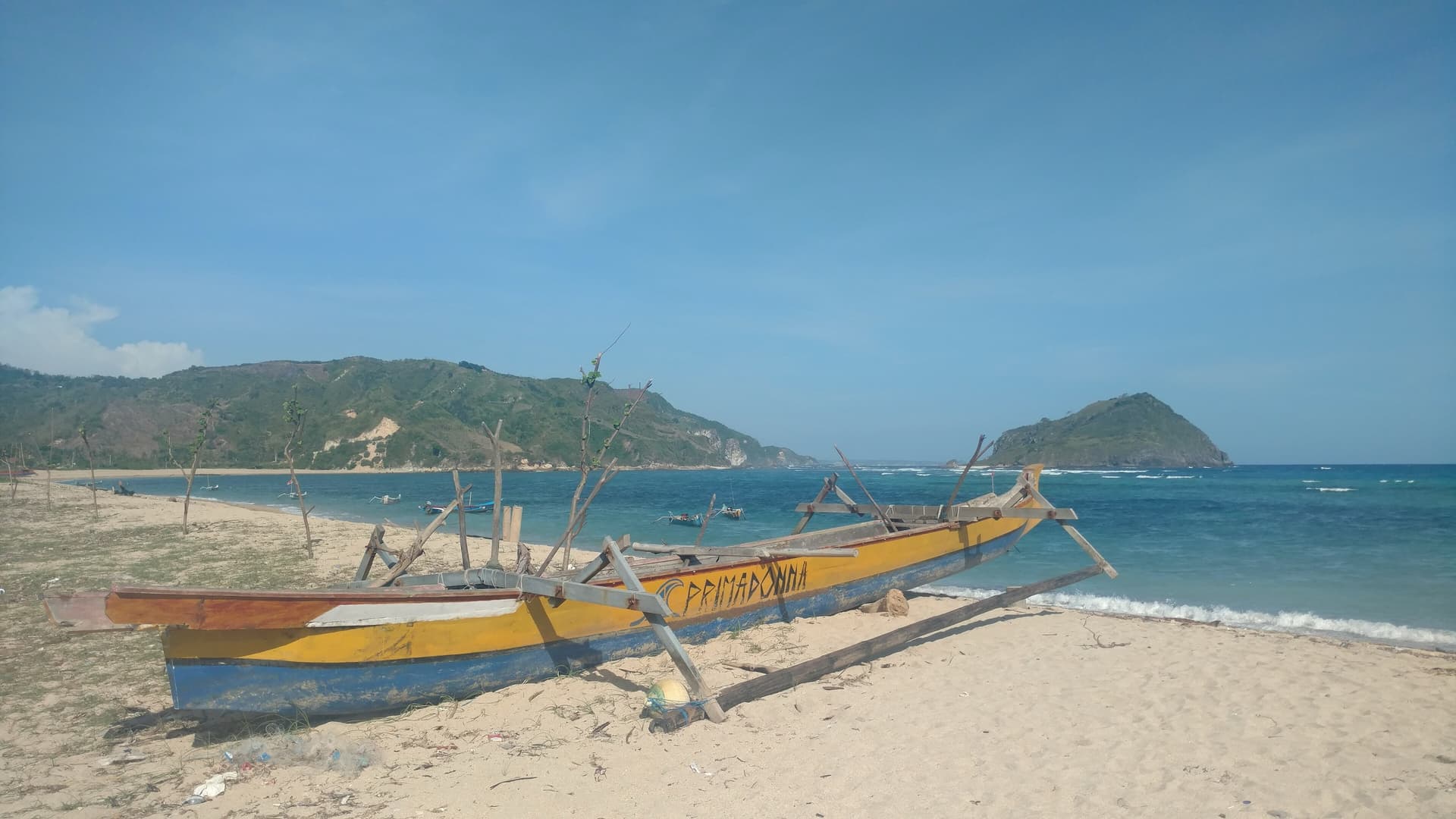 Wooden outrigger boat pulled up on a sandy beach