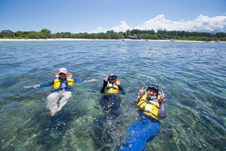 Three women snorkelling in clear shallow water